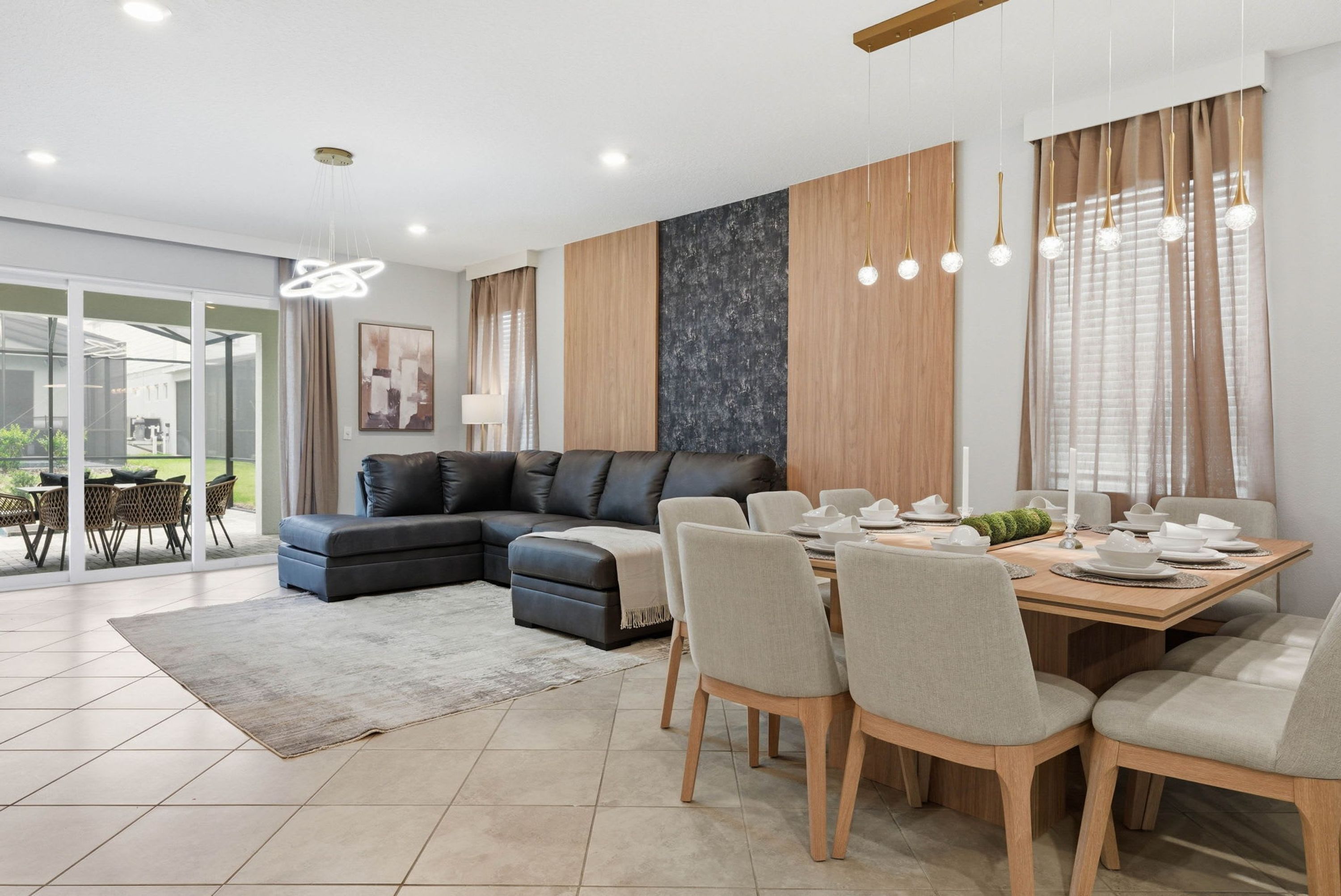 A modern living room with a sectional sofa, dining table, and chairs.
