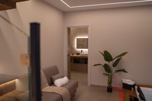 Ein modernes Badezimmer mit Waschbecken, Spiegel und einer Topfpflanze.