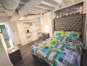 Ein Schlafzimmer mit Bett, Kleiderschrank und Spiegel.