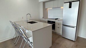 Eine moderne Küche mit einer zentralen Kochinsel, Edelstahlgeräten und einem minimalistischen Design.