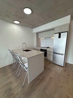 Eine moderne Küche mit einer zentralen Kochinsel, Edelstahlgeräten und einem minimalistischen Design.