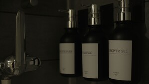 Drei Flaschen Duschgel, Shampoo und Conditioner.