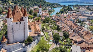 Eine historische Stadt mit einem markanten Turm, einem Fluss und historischen Gebäuden.