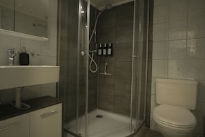 Ein Badezimmer mit Dusche, Toilette und Waschbecken.