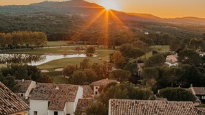 A residential area with houses, a golf course, and a hill in the background. - Riverfront Retreat Near Cannes (Mallemort)