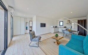 Un amplio salón con un sofá, una mesa de centro y una silla.