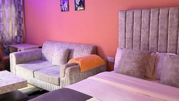 Une pièce comprenant un lit, deux canapés, une petite table et une chaise.