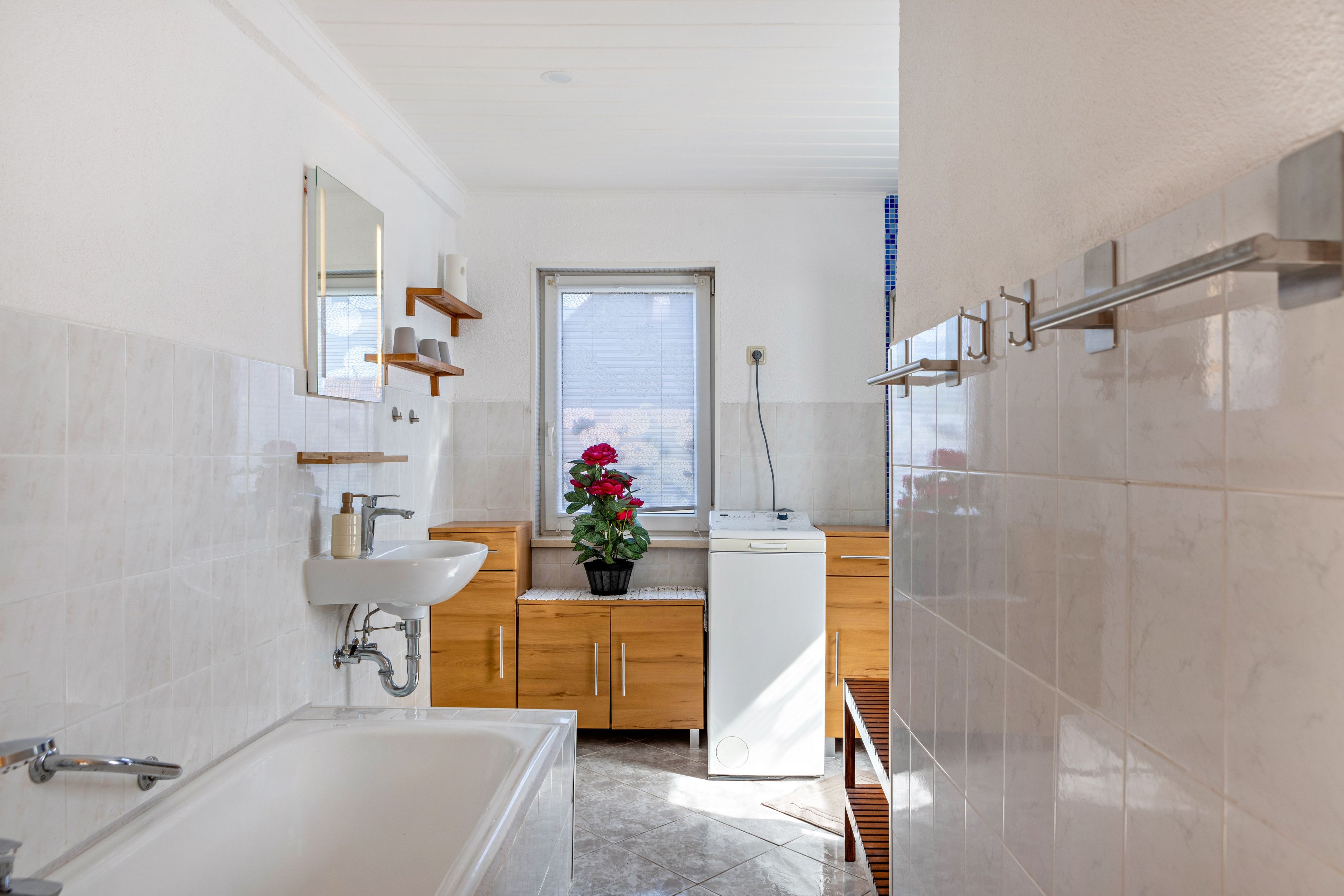 Un baño moderno con bañera, lavamanos y ventana con vistas.