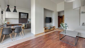 Un appartement moderne doté d’un coin repas, d’un téléviseur dans le salon et d’un design minimaliste.