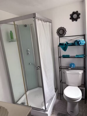 Een douche, handdoeken, zeep, toiletpapier