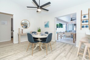 A dining area with a round table, chairs, a ceiling fan, and a view through an open door. - Beachside Getaway Minutes from the Gulf - Heated Pool - Sleeps 8 (Englewood)