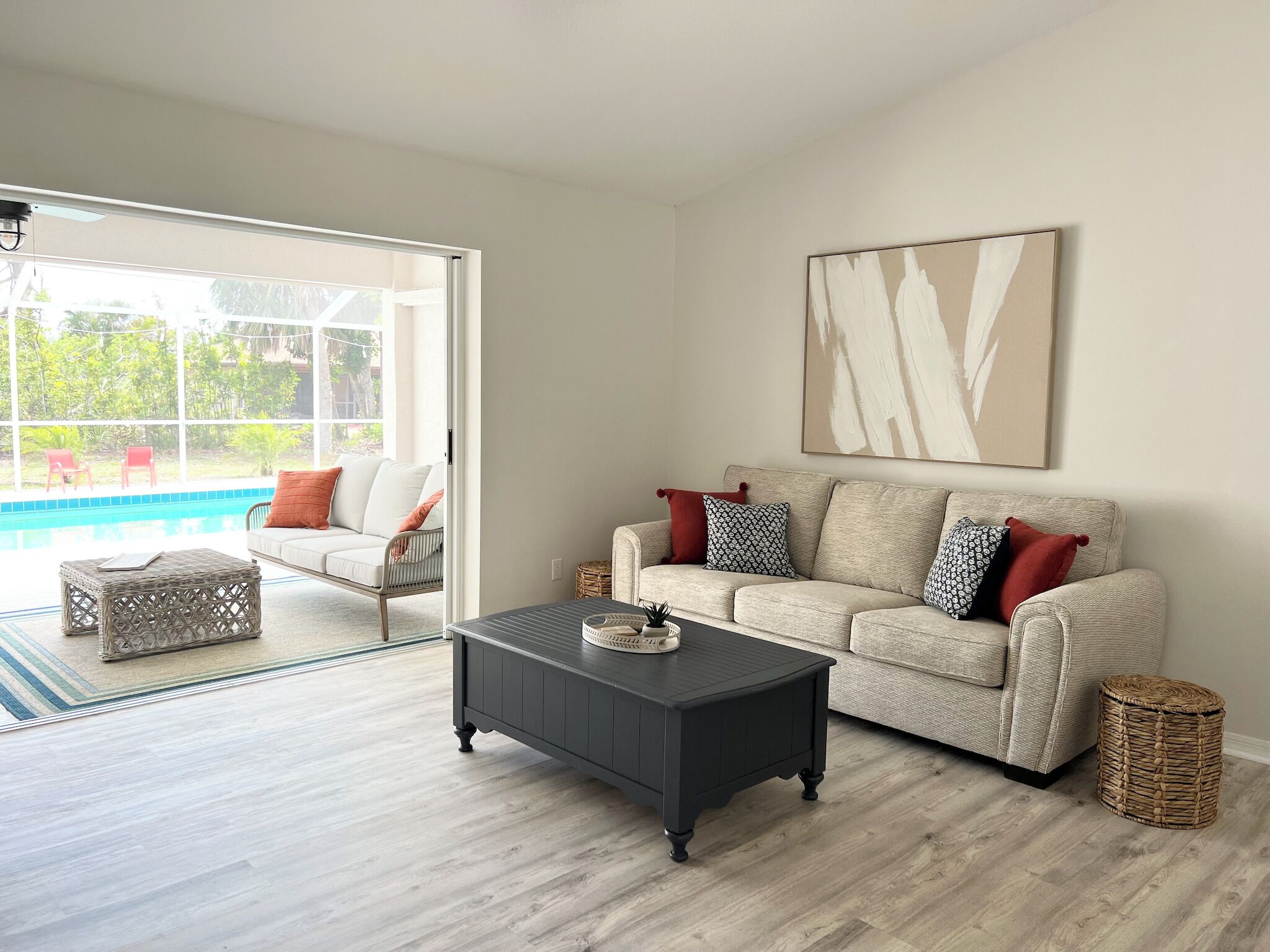 A living room with a sofa, a coffee table, and a large window.