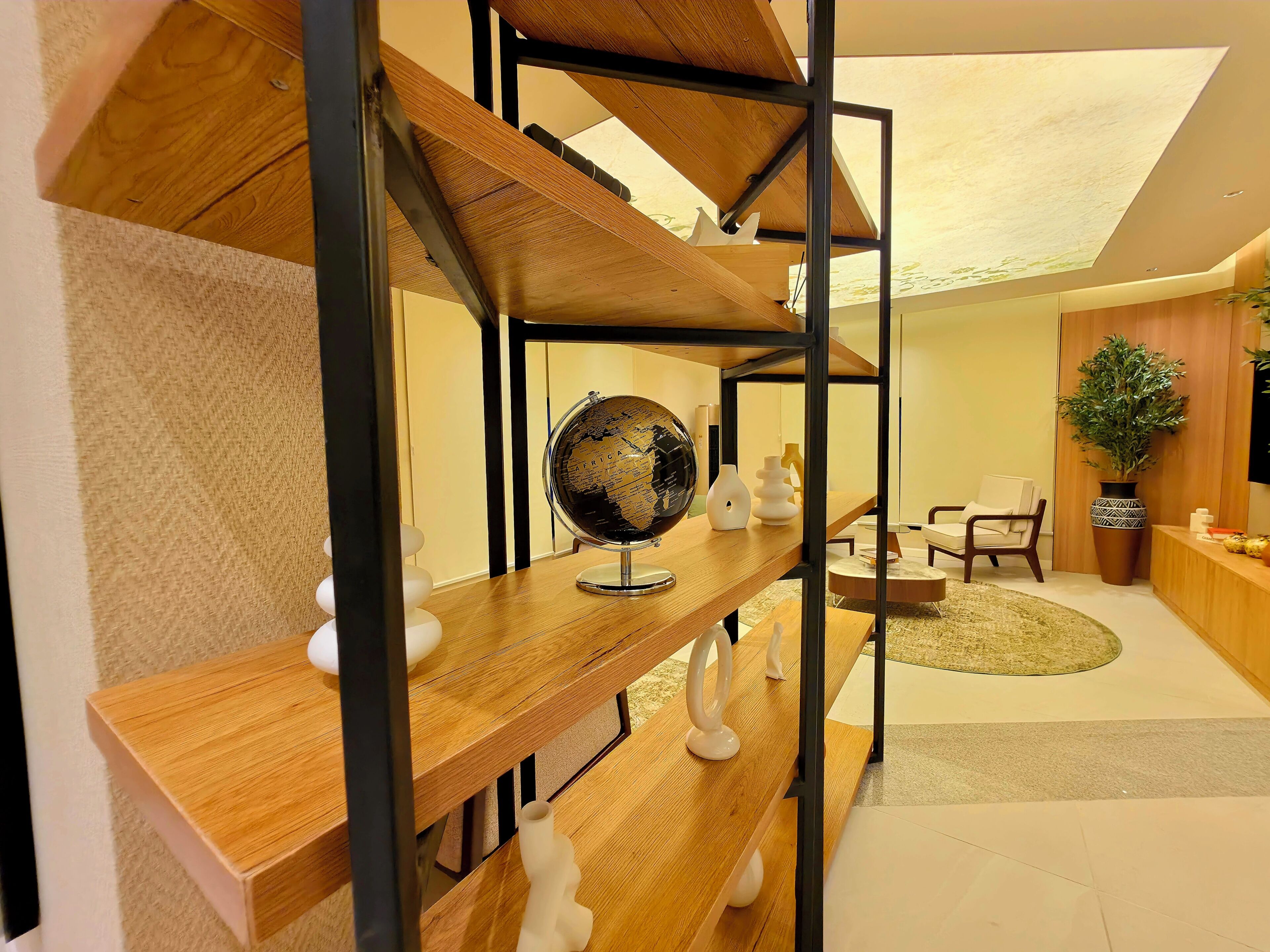 A modern interior with a wooden staircase, a globe, and a plant.