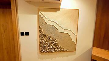 Una habitación con un relieve decorativo en la pared, una puerta de madera y un equipo de aire acondicionado blanco.