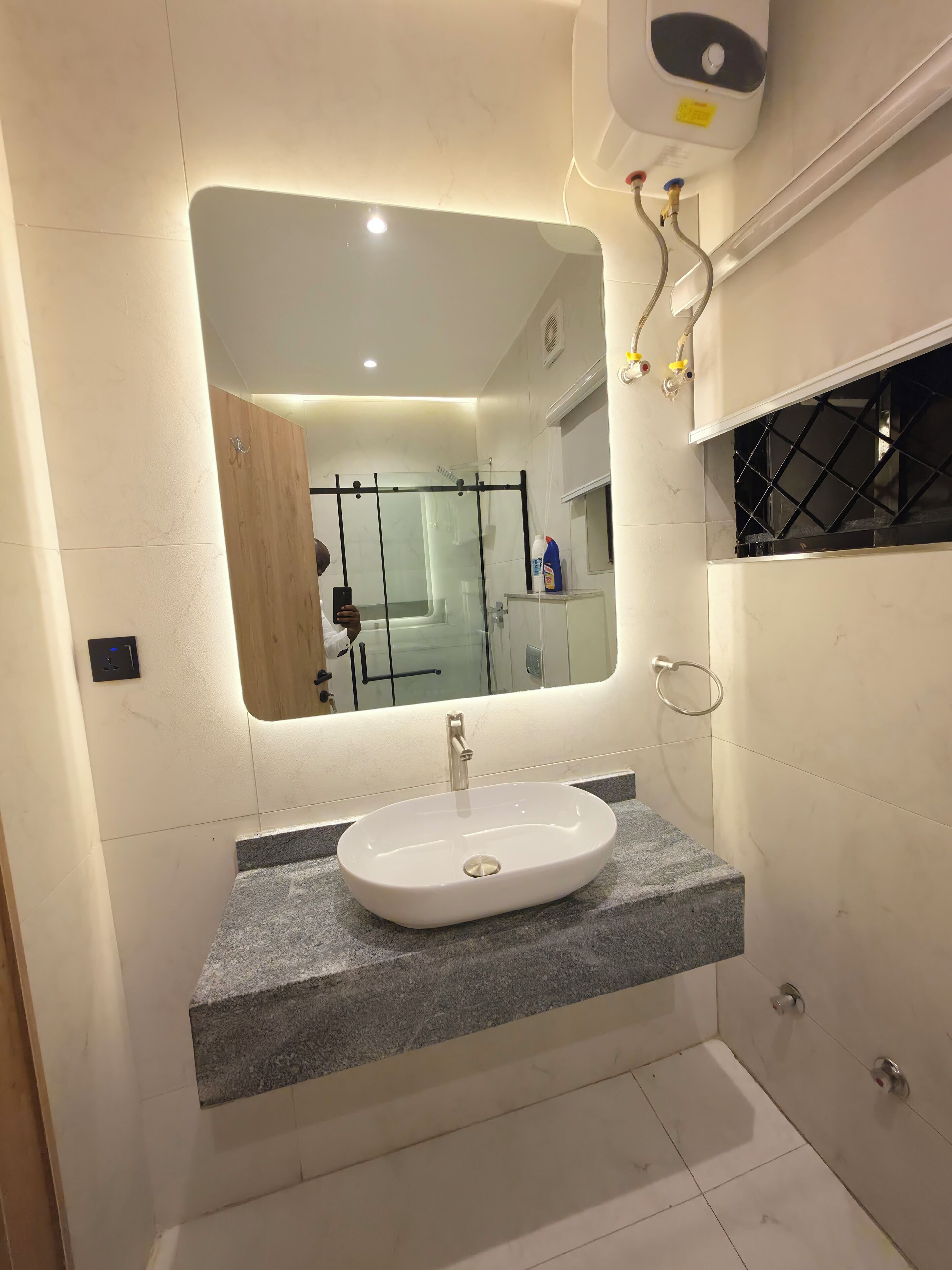 A bathroom with a white sink, a mirror, and a shower enclosure.