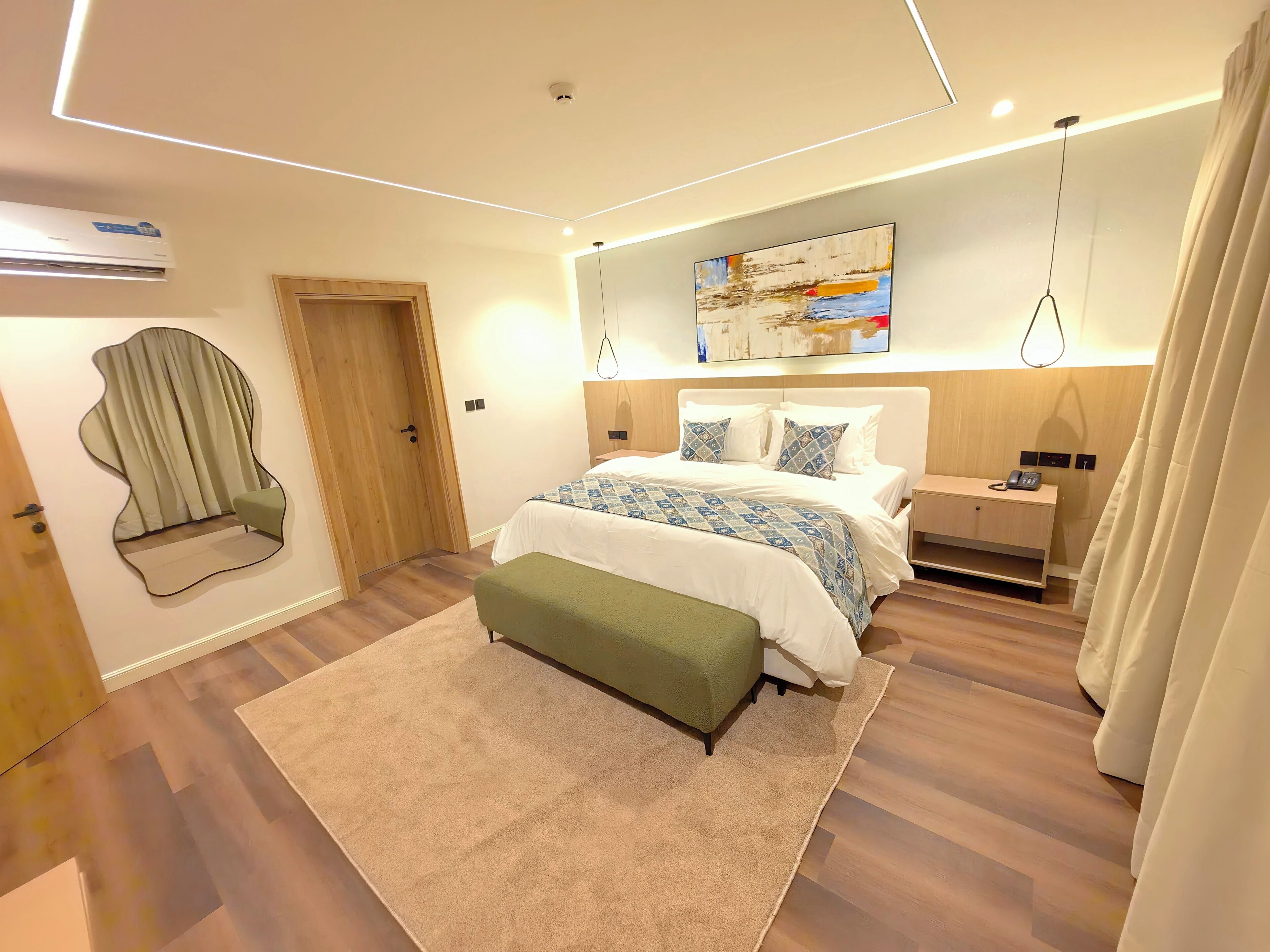 A modern bedroom with a bed, bedside table, and a hanging light fixture.