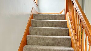 Eine Treppe mit Teppichstufen und Holzhandläufen.