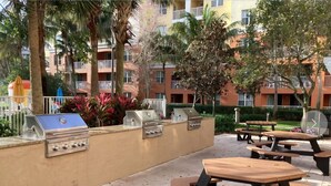 An outdoor patio with a grill, picnic tables, and a view of apartment buildings. - "Luxury and Comfort in Miami: for Family Holidays, in front of Sawgrass Mills". (Weston)