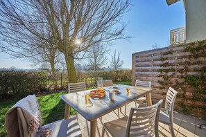 A patio table with chairs, a pitcher, glasses, and a tray. - Coastal Chalet for 6 With Pool (Courseulles-sur-Mer)