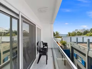 Un balcone con vista sulla città, una sedia e un tavolo.