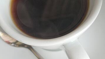 Una taza blanca de café con una cuchara sobre un platito.
