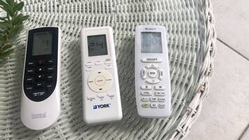 Tres controles remotos sobre una bandeja tejida.