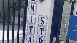 Una reja con un cartel que dice 'PALMITA STRAT' y una cabeza de venado decorativa.
