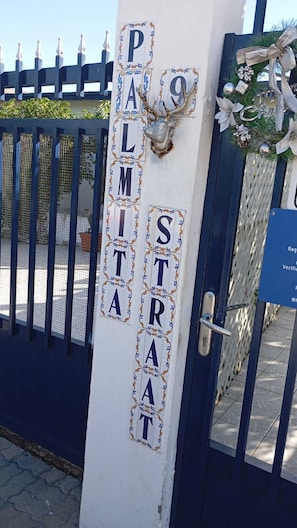 Una reja con un cartel que dice 'PALMITA STRAT' y una cabeza de venado decorativa.