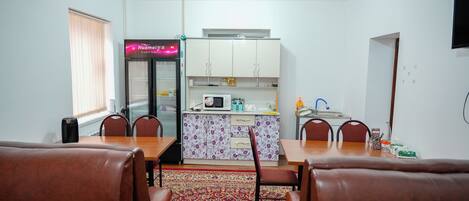 Un espacio habitable compacto con comedor, cocina y un pequeño rincón de descanso.