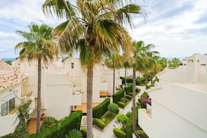 A residential area with white buildings, palm trees, and a well-maintained garden. - Nordic Bliss Marbella Townhouse (Marbella)
