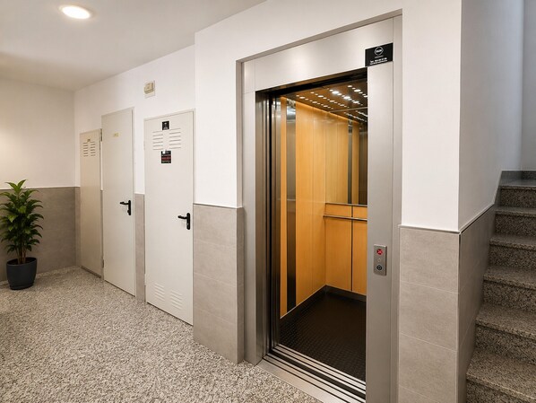 An elevator with a control panel, a potted plant, and a staircase. - Apartment for 3, a Short Walk From the Beaches (Roquetas de Mar)