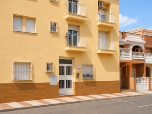 A multi-story building with balconies, a gated entrance, and a clear sky. - Apartment for 3 Near the Beach (Roquetas de Mar)
