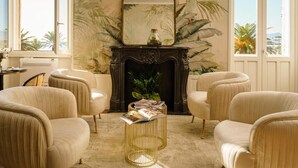 A room with a fireplace, a mirror, and a window with a view. - Birkin Porto 1870 (Cagliari)