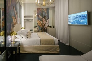 Quarto de hotel moderno com uma cama grande, televisão na parede e vista para a cidade.
