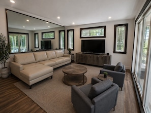 A modern living room with a sectional sofa, a coffee table, and a TV on a wooden cabinet.