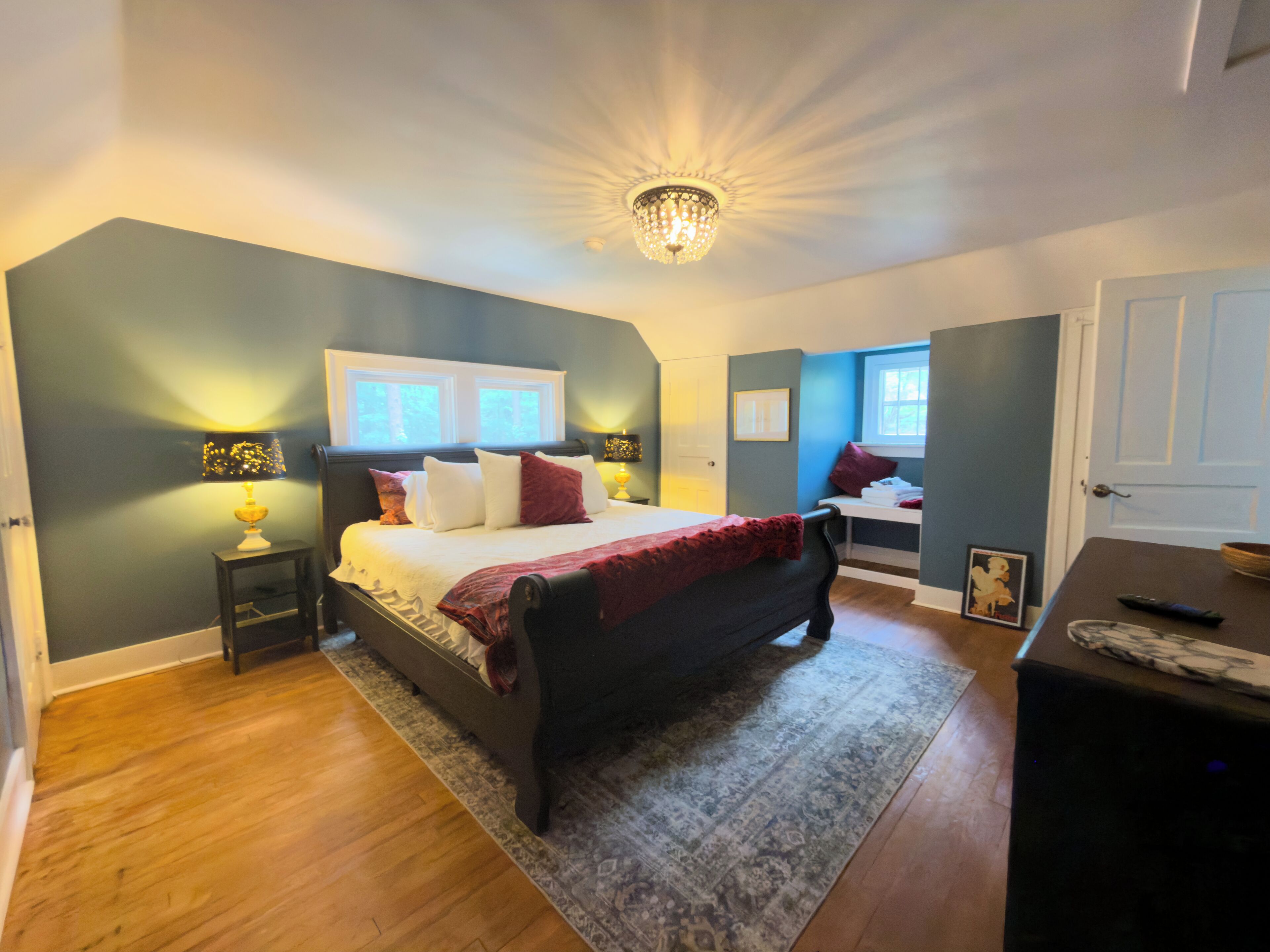 Une chambre à coucher comprenant un lit, des tables de chevet, une commode, un bureau et une chaise.