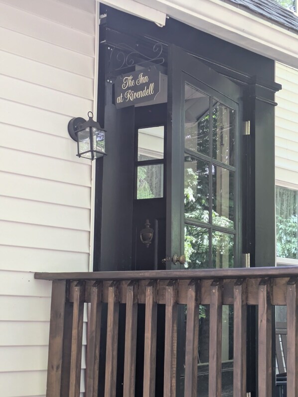 A black-framed entrance with a sign reading 'The Inn at Rivendell' and a wooden deck in front.