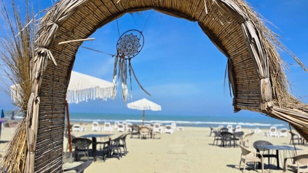 A beach with a thatched archway leading to a wooden deck. - Sea Dream Studio Qerret (Golem)