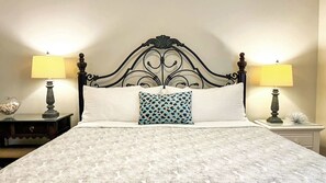 A bed with a patterned bedspread, a decorative pillow, and two bedside lamps. - Horizon South 81B Resort Stay (Panama City Beach)