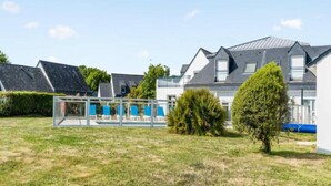 A residential area with houses, a grassy lawn, and a clear sky. - Stunning Oceanfront Haven for 2 (Île-aux-Moines)