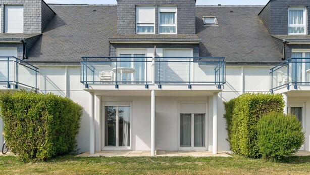 A modern residential building with a flat roof, white exterior walls, and a balcony with a glass railing. - Stunning Oceanfront Haven for 2 (Île-aux-Moines)