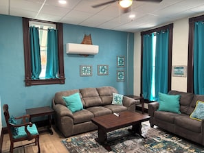 A living room with two sofas, a coffee table, a wooden chair, and a rug.