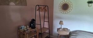 A bedroom with a bed, a nightstand with a lamp, a hanging plant, a coffee maker, and a shelf with mugs and a box. - Between the sea and the mountains, a quiet independent room with a view! (Neffiès)