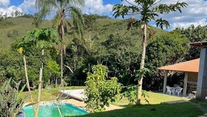 Una piscina rodeada de césped, con un patio y un edificio al fondo.