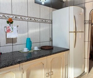 Una cocina con un refrigerador blanco, una encimera de granito y un salpicadero con un borde de azulejos decorativos.