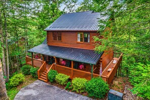 Eine Hütte mit Veranda, Treppe und einer Terrasse.