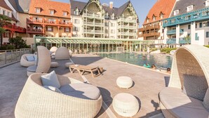 A rooftop pool area with wicker lounge chairs and a glass balustrade. - Premium Deauville Spa Apartment for 8 (Deauville)