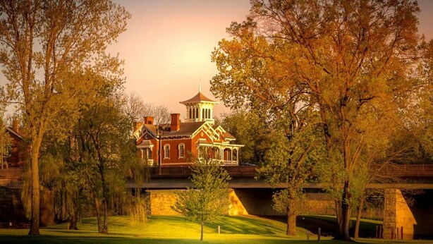 A large, historic building with a prominent tower, surrounded by lush trees and a well-maintained lawn. - Dog friendly(with dog fee),Close to Downtown,Historic District, (Galena)