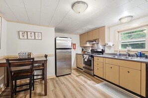 A kitchen with a stainless steel refrigerator, an oven, and a sink. There is a window with a view of greenery outside. - Dog friendly(with dog fee),Close to Downtown,Historic District, (Galena)