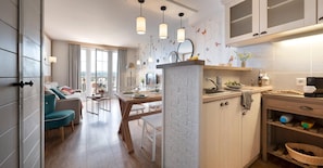 A modern kitchen with a dining area, large windows, and a view of the city. - Houlgate Duplex Apartment for 6 (Houlgate)